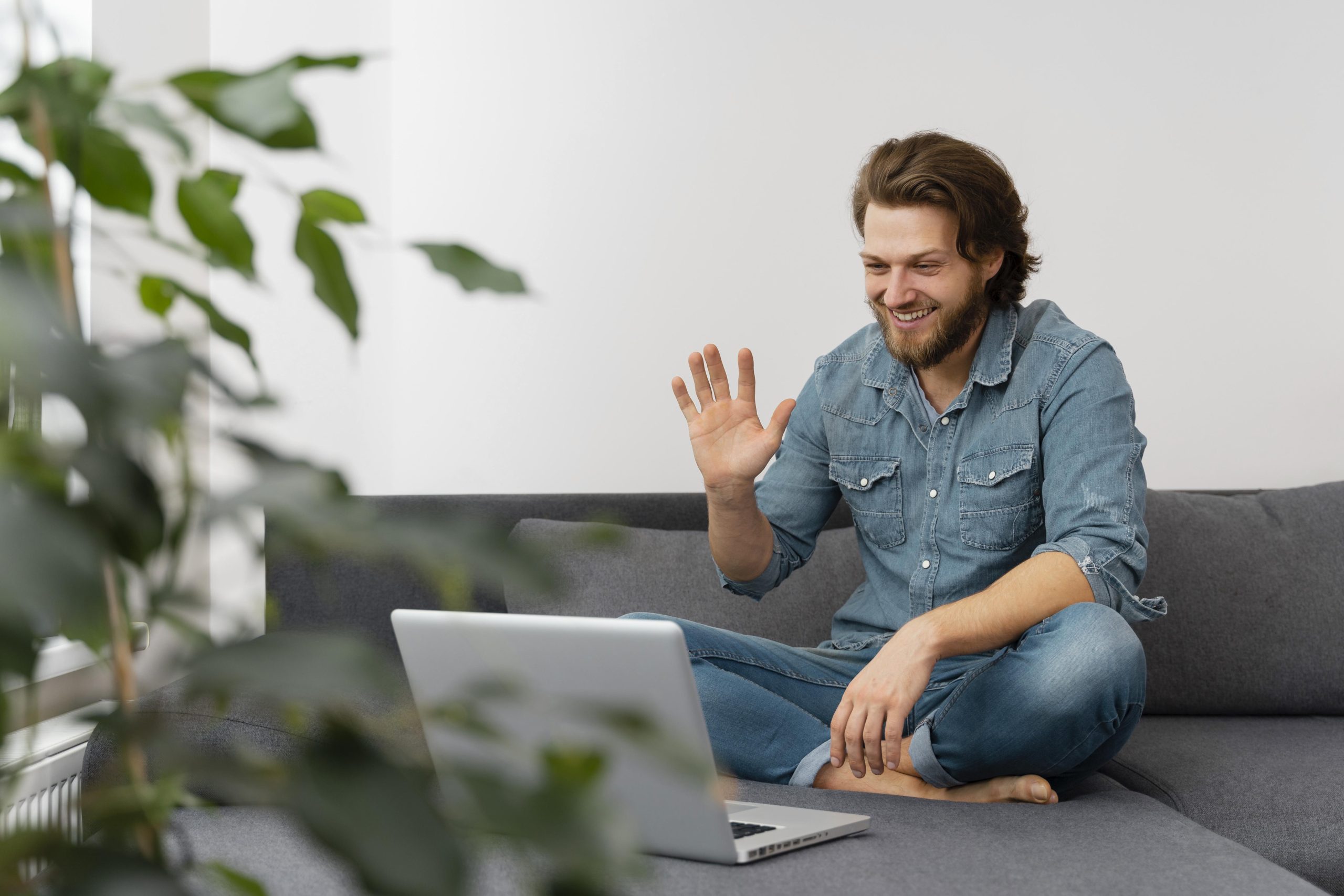 full-shot-man-waving-laptop